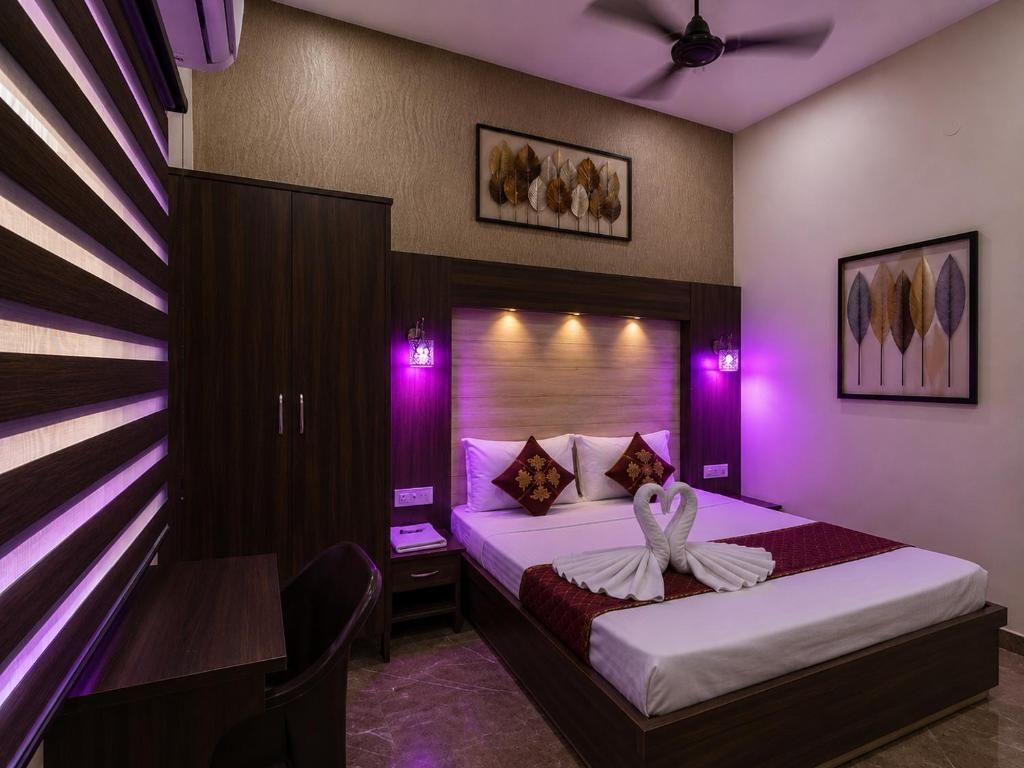 Una habitación de hotel con cama, mesita de noche y escritorio.