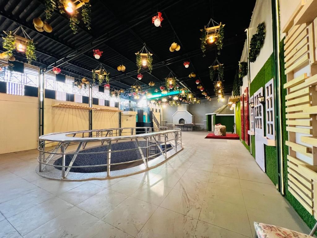 Amplio espacio interior con una zona de estar circular, una escalera y una pared verde con una puerta blanca.
