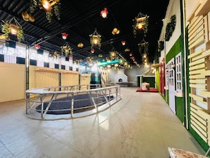 Amplio espacio interior con una zona de estar circular, una escalera y una pared verde con una puerta blanca.
