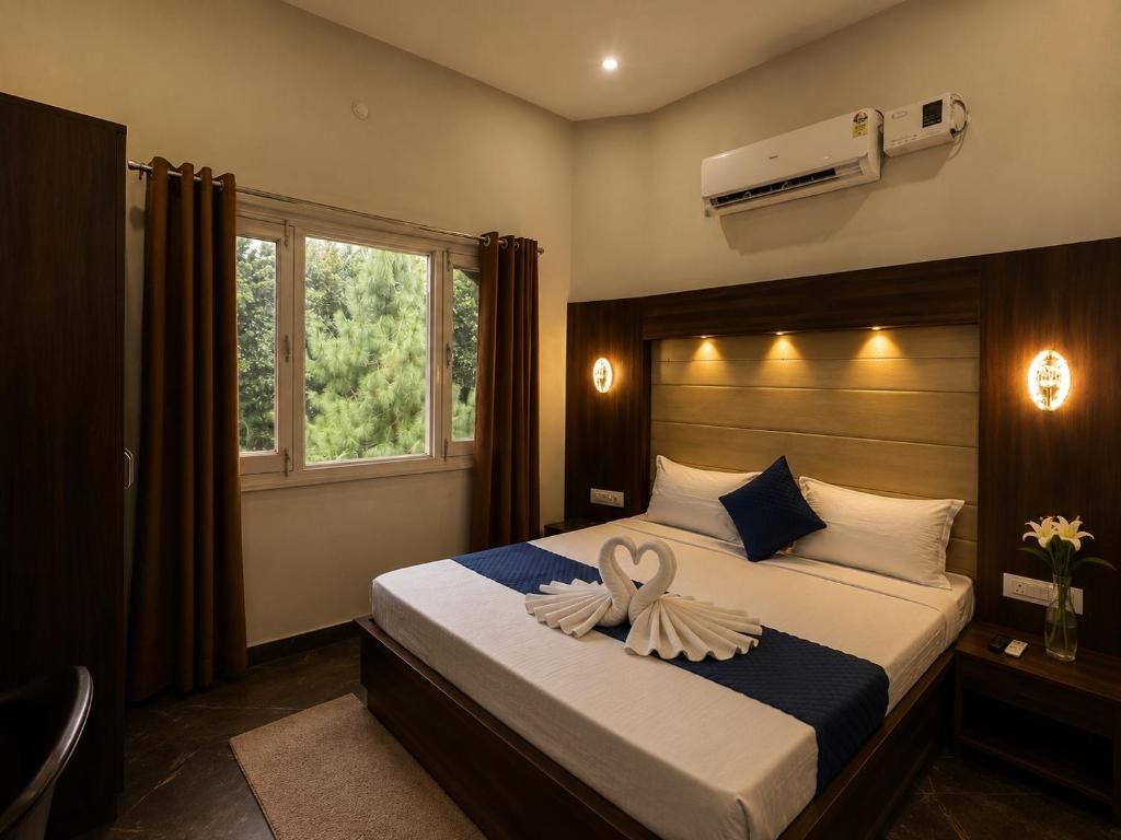 Habitación de hotel con una cama grande, una ventana con cortinas, un equipo de aire acondicionado y una mesita de noche con un florero.