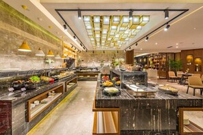 Un área de bufé con mostradores de mármol y una variedad de alimentos.