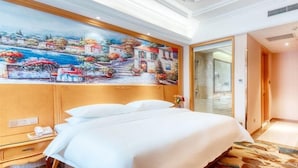 A hotel room with a large bed, a painting on the wall, a wooden nightstand, and a bathroom door. - Vienna International Hotel (Tianjin)