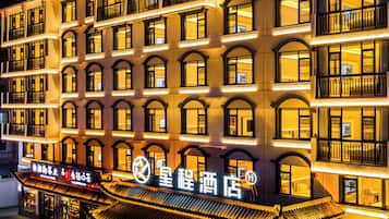A multi-story hotel with traditional architectural features, including arched windows and a tiled roof.
