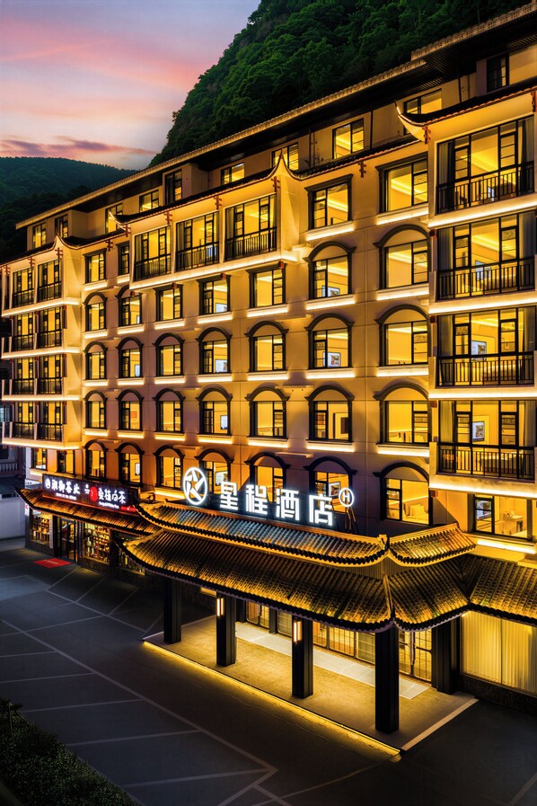 A multi-story hotel with traditional architectural features, including arched windows and a tiled roof.