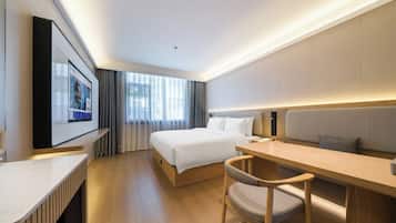 A modern hotel room with a bed, a desk, a chair, and a large window.