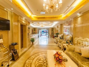 A hotel lobby with a reception desk, seating area, and a chandelier. - Vienna 3 Best Hotel (Wuhan)