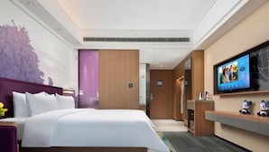 A modern hotel room with a large bed, a television, a desk, and a bathroom visible through an open door. - Hampton by Hilton Changchun High-tech Zone (Changchun)