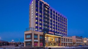A multi-story hotel with a prominent 'Hampton' sign on the facade, featuring a modern architectural design with a flat roof and a series of balconies. - Hampton by Hilton Changchun High-tech Zone (Changchun)