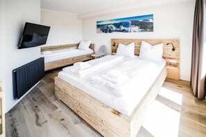 A hotel room with two beds, a TV, and a painting of a snowy landscape. - Holiday apartment 705 (Winterberg)