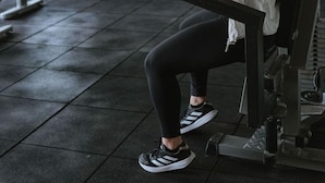 Ett gym med träningsutrustning, ett löpband och en spegel.