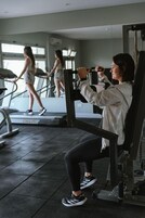 Un gimnasio con equipo de ejercicio, una cinta de correr y un espejo.