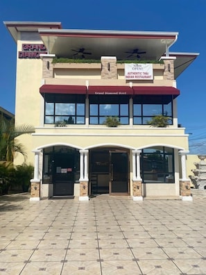 A hotel with a sign indicating it is now open, featuring an authentic Thai Indian restaurant. - Grand Diamond Hotel (Piarco)
