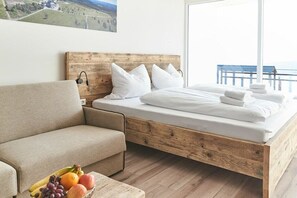 Een slaapkamer met een houten bedframe, een sofa en een fruitmand op de vloer.