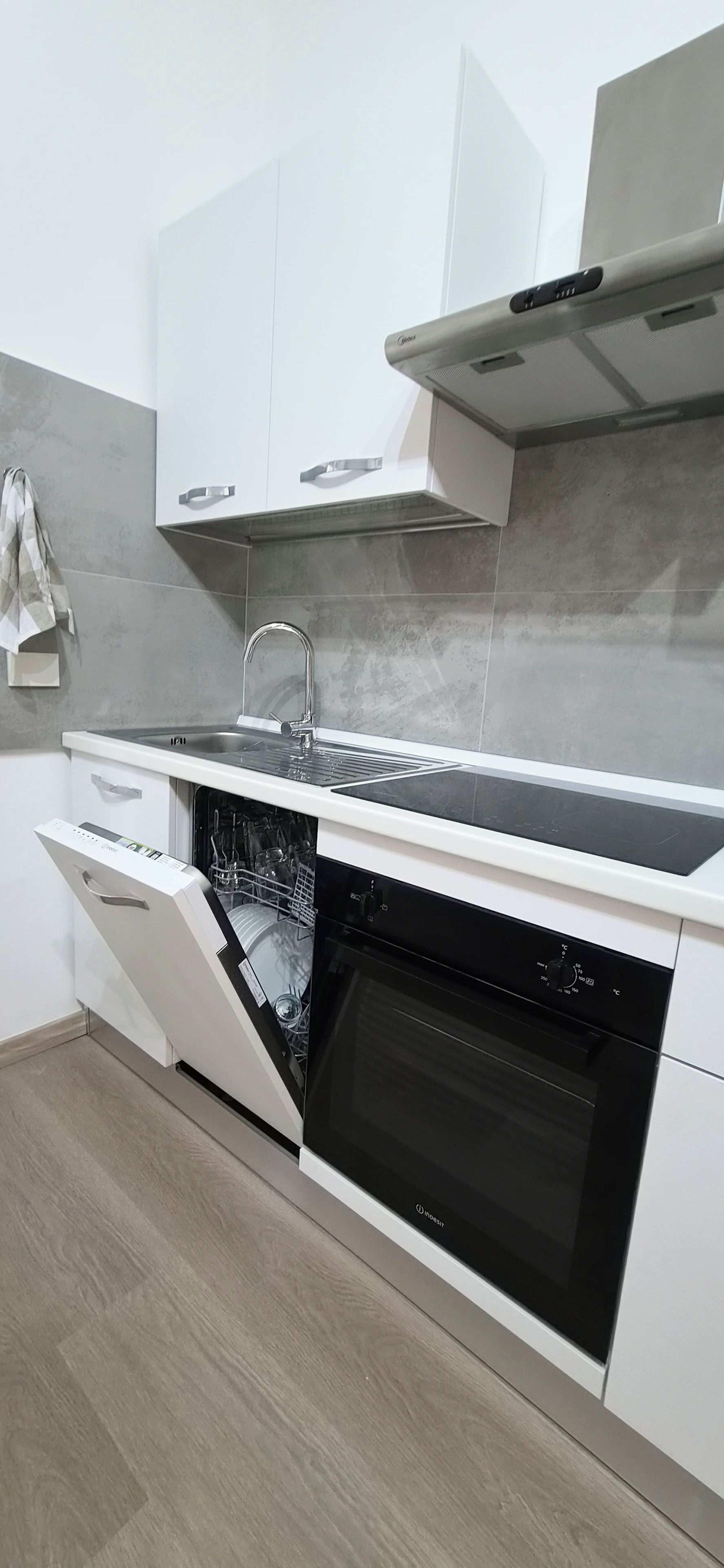 Eine moderne Küche mit Geschirrspüler, Backofen und Kochfeld.