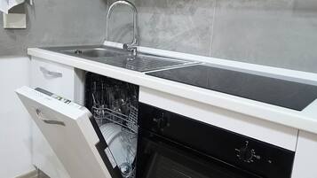 Eine moderne Küche mit Geschirrspüler, Backofen und Kochfeld.