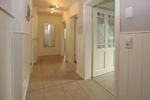 A hallway with white doors, a tiled floor, and a light fixture on the ceiling. - 2 in Huus Starklef, Starklef 34a (Wyk auf Föhr)