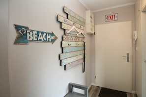 A hallway with a directional sign pointing to the beach, a coat rack, and an exit sign. - E2 "Nordmeer" at Feldstr. 18 (Wyk auf Föhr)