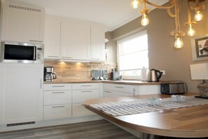A modern kitchen with white cabinetry, a microwave, a coffee maker, and a toaster. - E2 "Nordmeer" at Feldstr. 18 (Wyk auf Föhr)