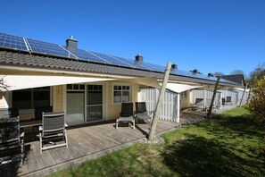 A residential property with a covered patio, solar panels, and a fenced backyard. - Cockle at Susanne-Fischer-Weg 53 (Wyk auf Föhr)