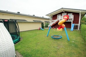 A residential backyard with a trampoline, a swing set, and a slide. - Shrimp in Susanne-Fischer Weg 33 (Wyk auf Föhr)