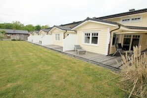 A row of mobile homes with a grassy yard and a wooden deck. - Lapwing at Susanne-Fischer-Weg 31 (Wyk auf Föhr)