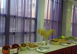 A buffet table with various dishes and utensils.