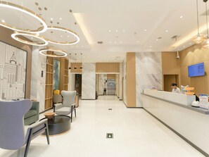 A modern reception area with a marble floor, a reception desk, and a seating area with chairs. - City Comfort Inn Yichang East Railway Station (Yichang)