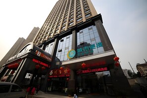 Un edificio de varios pisos con señalización comercial, incluyendo un restaurante y una oficina.