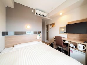 A hotel room with a bed, desk, chair, television, and a small kitchenette. - Super Hotel Totsuka Eki Higashiguchi (Yokohama)