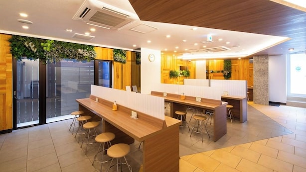 Un interior moderno con paneles de madera, una recepción y taburetes de bar.