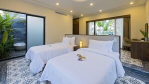 A hotel room with two beds, a desk, a chair, and a large window. - Cocoland River Beach Resort and Spa (Tu Nghia)