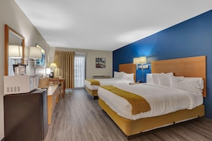 A hotel room with two beds, a desk, a chair, a microwave, and a television. - Spicer Hotel (Spicer)