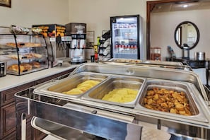A buffet area with various food options, a coffee machine, and a refrigerator. - Spicer Hotel (Spicer)