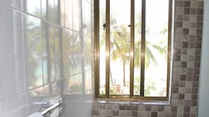 A bathroom with a window, tiled walls, and a towel rack. - Villa Dahl Beach Resort (Dar es Salaam)
