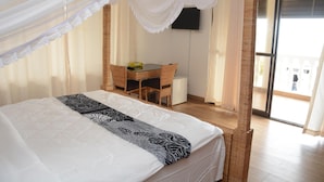 A bedroom with a bed, a desk, and a chair. - Villa Dahl Beach Resort (Dar es Salaam)