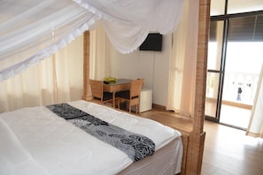 Quarto com cama, escrivaninha e cadeira.