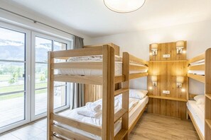A bunk bed room with a view of a mountainous landscape through large windows. - Superior Holiday Home # 5C with Sauna (Uttendorf)