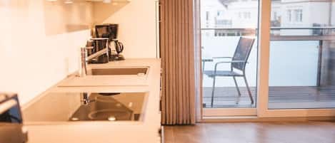 A modern kitchen with a large window and a view of a balcony.