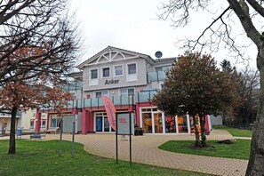 Ein Gebäude mit einem Schild mit der Aufschrift 'Anker' und einem gepflasterten Weg, der davorführt.
