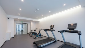 A gym with treadmills, stationary bikes, and a wall-mounted screen. - Holiday Inn Express Huludao Seaview an IHG Hotel (Huludao)