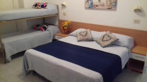 Una habitación de hotel con una cama, un banco y una mesita de noche con una lámpara.