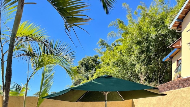 Un espace extérieur aménagé avec une table, des chaises, un parasol et des statues décoratives.