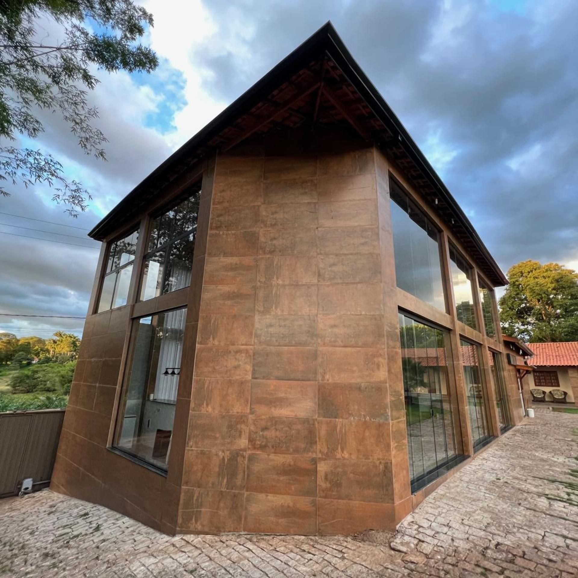 Um edifício moderno com estrutura angular marcante, grandes janelas e fachada de pedra.