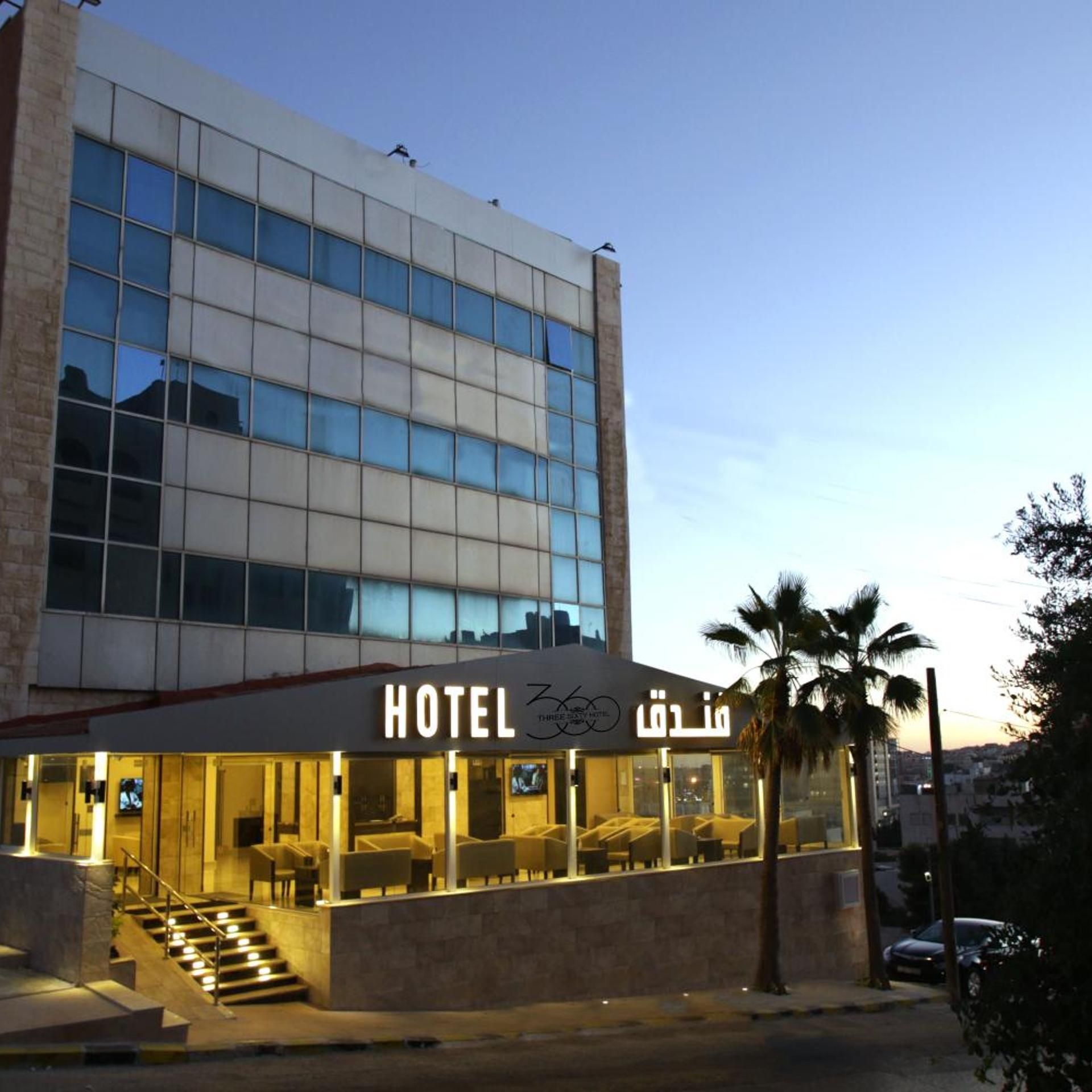 A hotel with a modern facade, large windows, and a well-lit entrance.