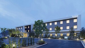 Un moderno edificio di un hotel con un cartello che riporta 'Fairfield by Marriott'.