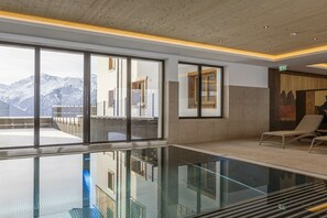 A modern indoor swimming pool with large windows and a mountain view. - Penthouse with 5 bedrooms (Mittersill)