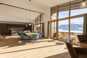 Eine moderne Küche mit Essbereich, großen Fenstern und Blick auf eine verschneite Landschaft.