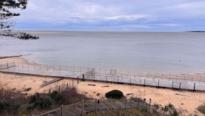 A beach with a wooden boardwalk leading to a fenced area. - Villa Pyla - Côte d'Azur, 7-bedroom villa with private beach access (La Teste-de-Buch)