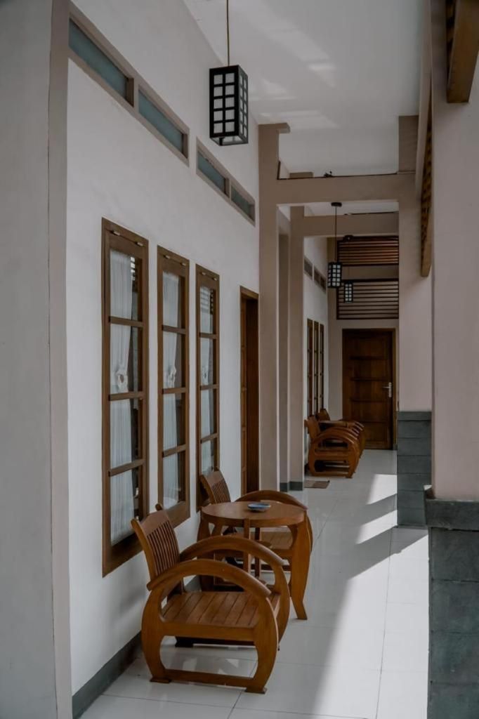 A corridor with wooden furniture and a hanging light fixture.