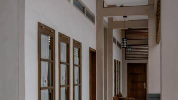 A corridor with wooden furniture and a hanging light fixture.